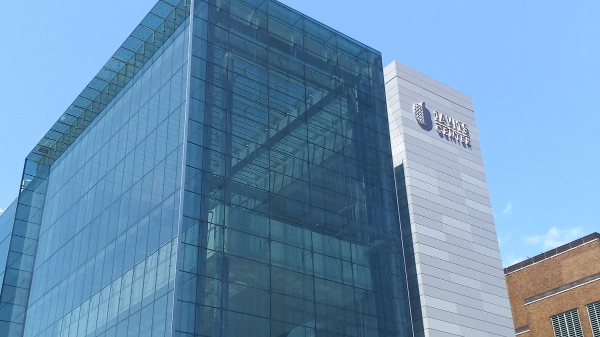 The glass curtain wall of the Javits Center in Manhattan, with its name on the tower